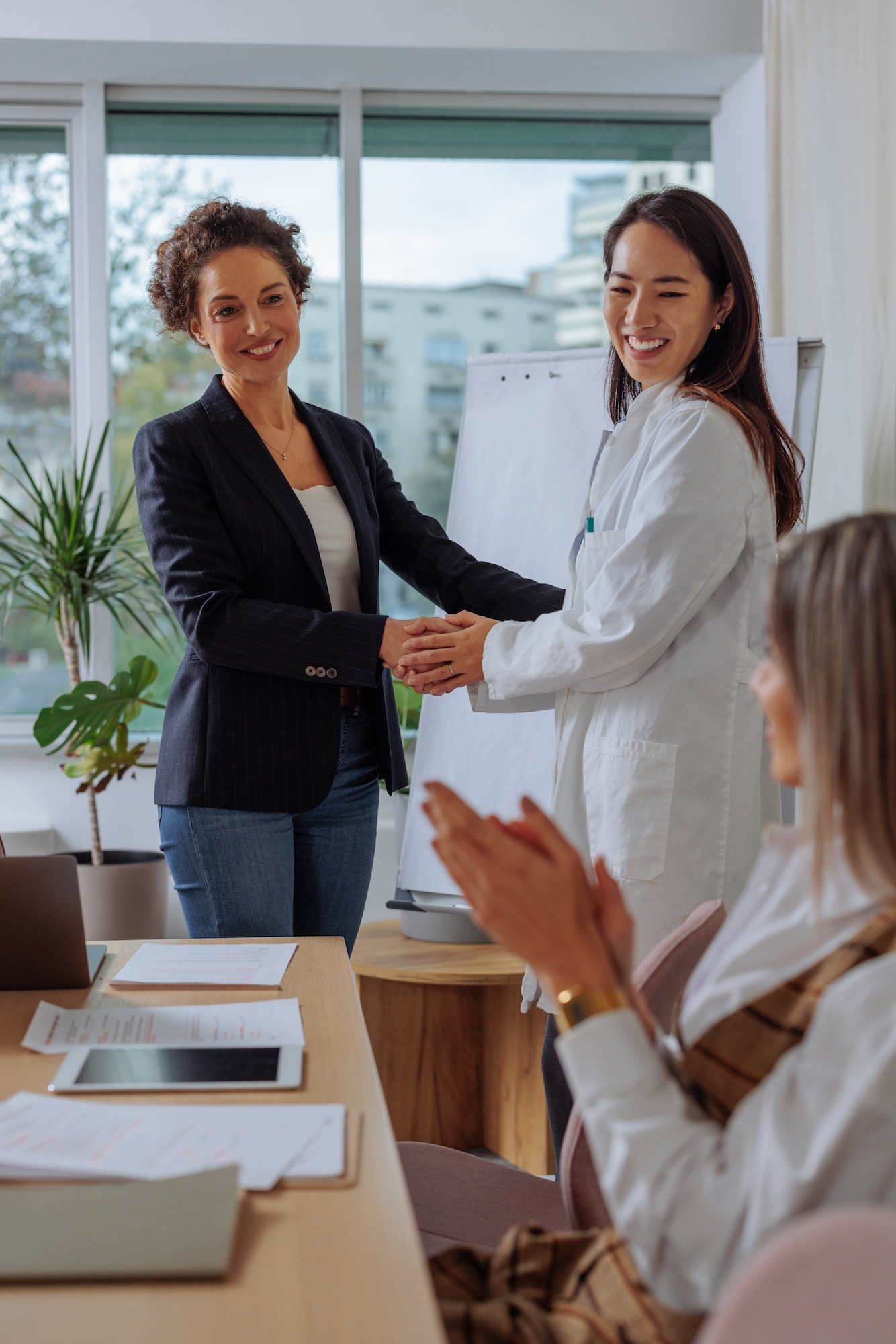 Businesswoman shaking hand with female doctor after presentation Businesswoman shaking hand with female doctor after presentation
